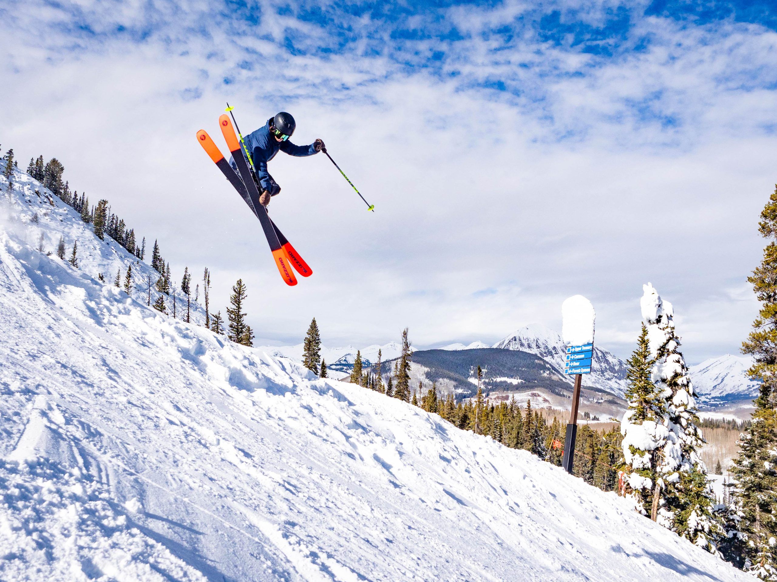 A skier jumps on a steep run